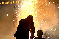 Father and son bursting crackers on Diwali