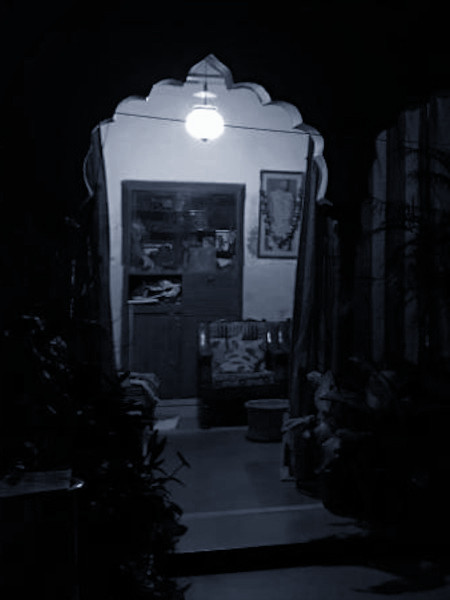 As night falls, lamps from an older era throw the courtyard into shadows.