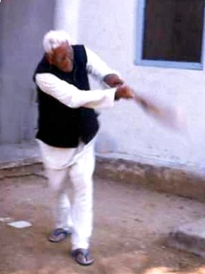 Khemchandji with a cricket bat in an on-drive.